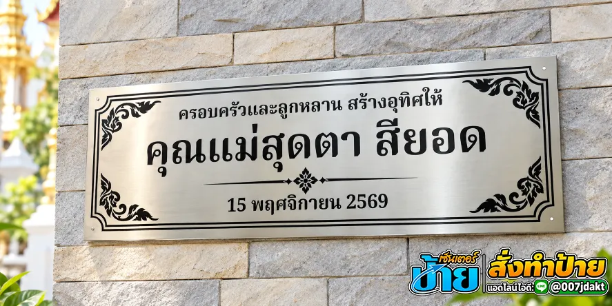 ป้ายบริจาคสแตนเลสกัดกรดสีเงินผิวปัดลายแนวนอน ข้อความสีดำ ครอบครัวและลูกหลานสร้างอุทิศให้คุณแม่สุดตา สียอด วันที่ 15 พฤศจิกายน 2569 ตกแต่งกรอบลายไทยทั้งสี่มุม ติดตั้งบนผนังหินธรรมชาติ